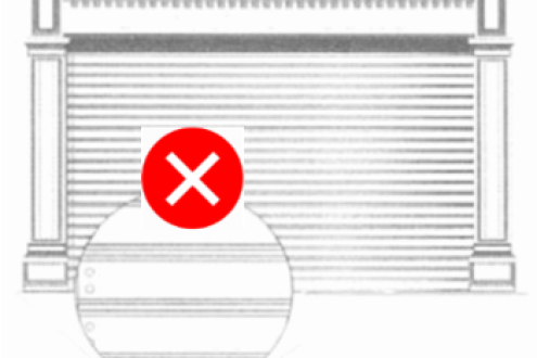 Closed metal roller shutter with horizontal slats and a magnified detail inset; a red circle with a white “X” overlays the inset, indicating the shutter type is not allowed.