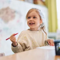 Nursery child holding a pen