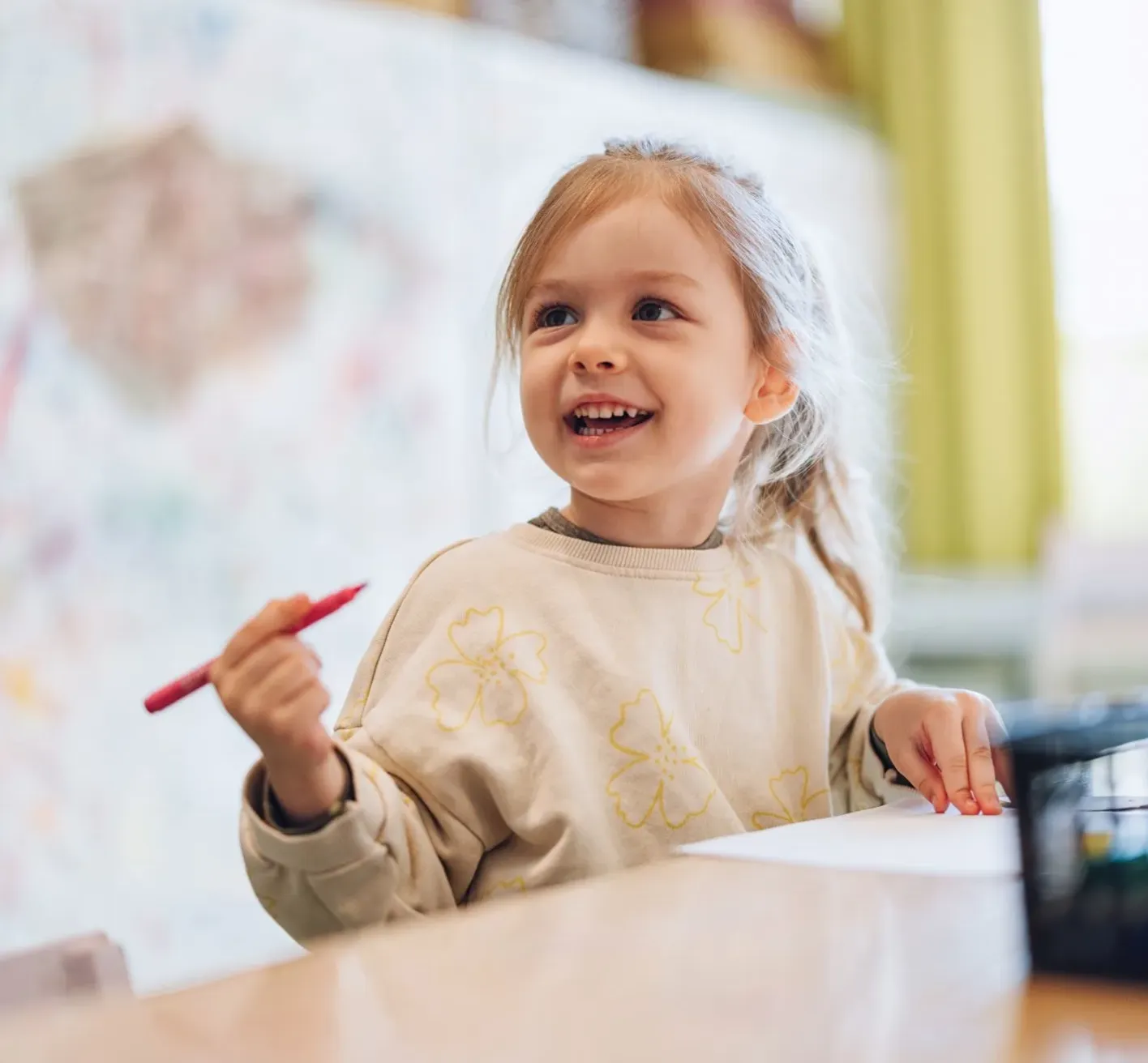 Nursery child holding a pen