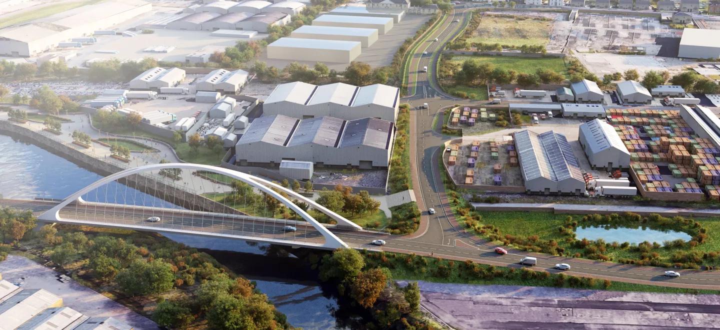 View from above of a bridge over a river with large warehouse type of buildings.