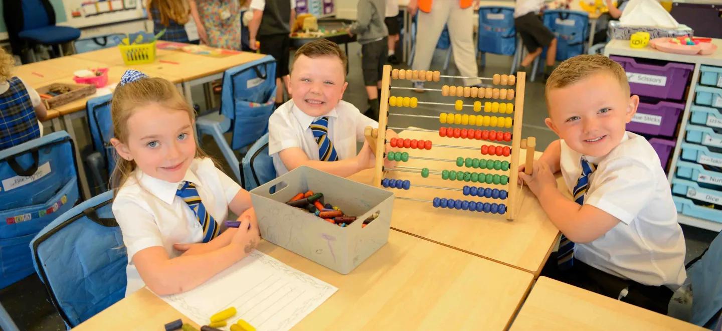 Children sitting at desk in a classroom on their first day of primary school.