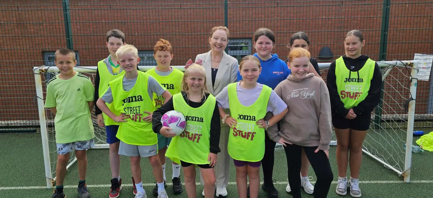 A group of children smiling in front of a football goal