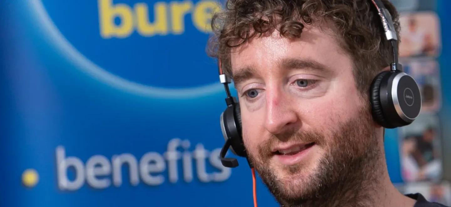 An adviser wearing a headset talking to someone on a call.