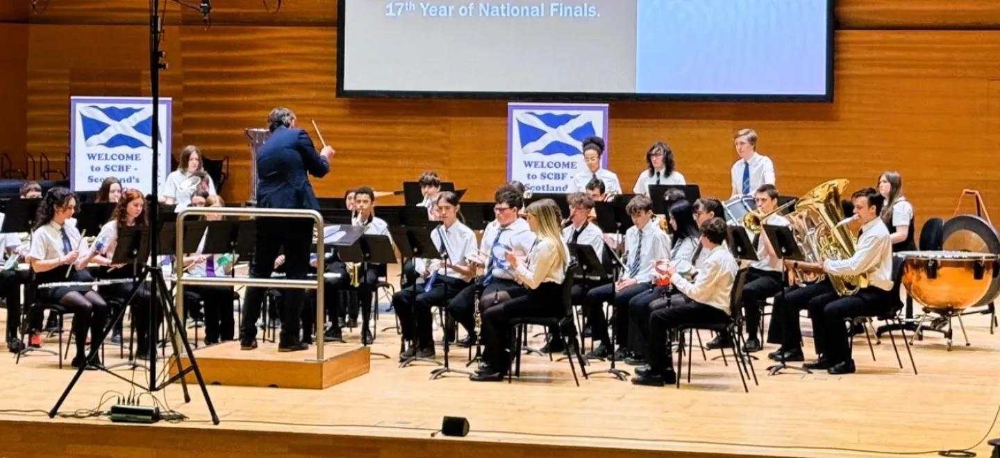 Young musicians seated on stage to play instruments for national awards festival.