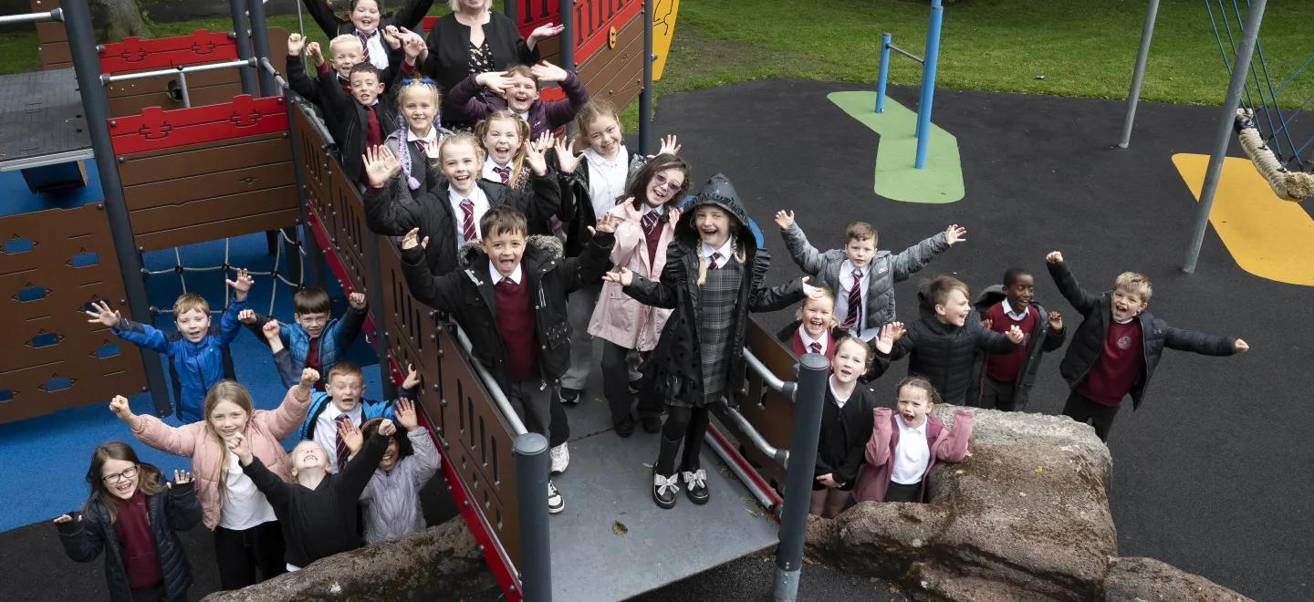 A group of P3 pupils stand at new play ship with councillor
